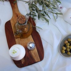 Aceite de oliva virgen extra Terrvs en un ambiente mediterráneo con aceitunas y utensilios de cocina.